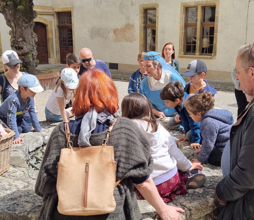 Guide montrant l'utilisation d'un puit à un groupe d'enfants