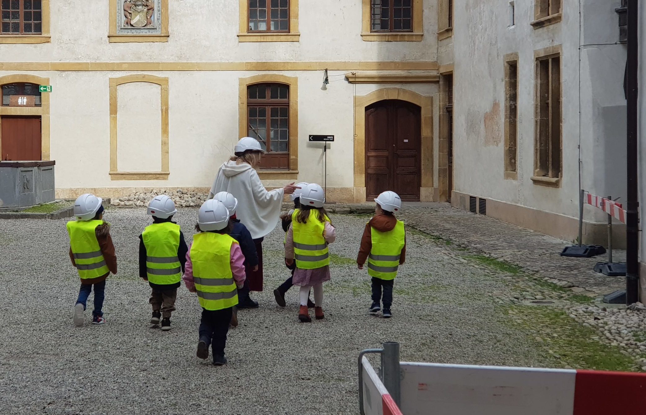 Visite-guidee-chantier-ecole groupe d'enfants en tenue de chantier et suivant une guide