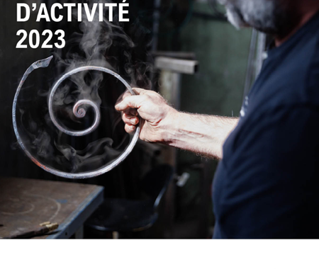 Forgeron tenant une volute en fer forgé.